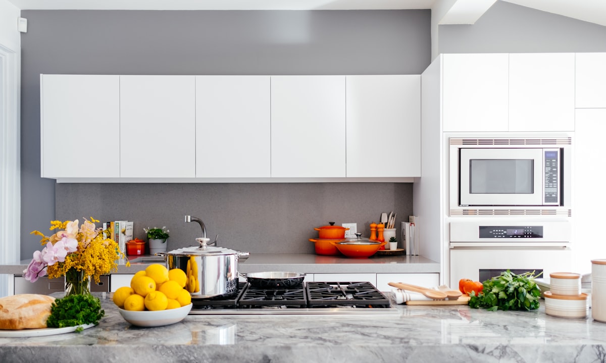 Minimal kitchen with stone surfaces and soft neutral cabinetry